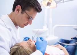 Doctor examining woman with dental equiptments