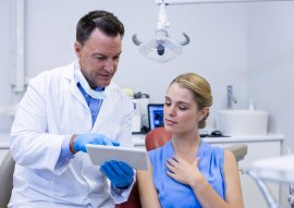 dentist discussing over digital tablet